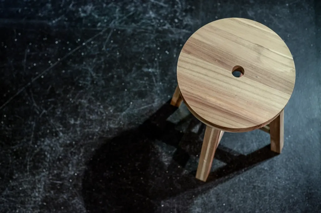 Rond houten krukje op een donkere vloer